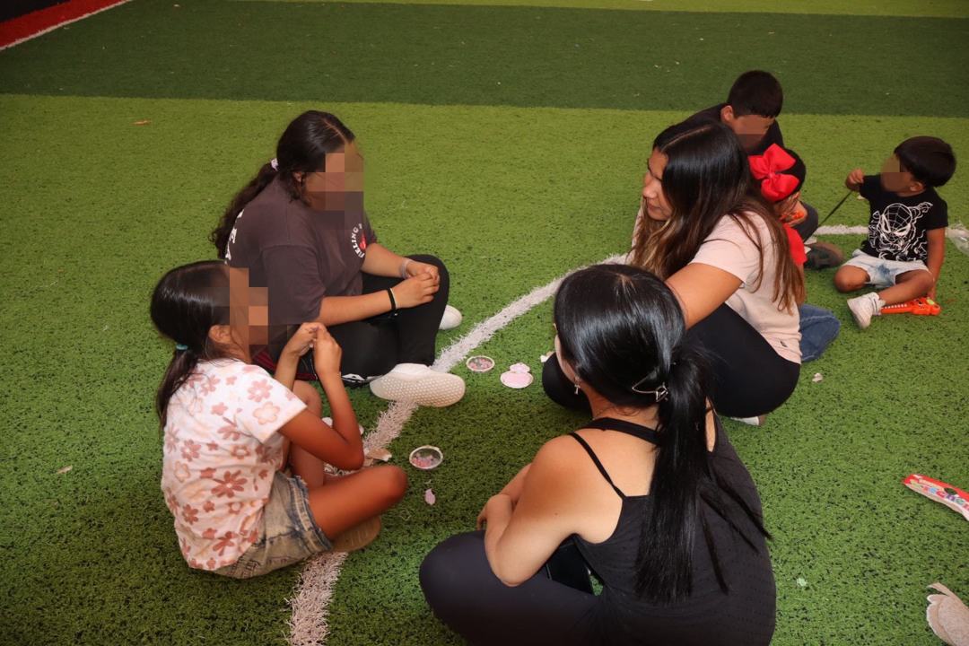 Voluntarias haciendo manualidades con dos niñas